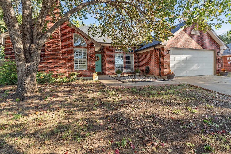 View of front of house featuring brick siding, concrete driveway, and a garage
