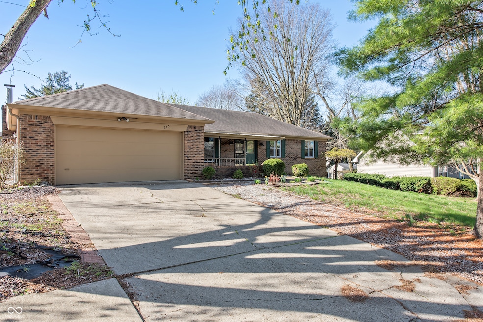 single story home featuring brick siding, driveway, covered porch, and a garage
