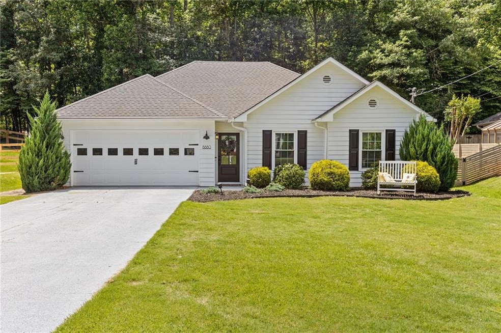 Ranch-style home featuring a garage, driveway, and roof with shingles