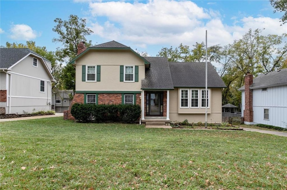 View of front of property featuring brick siding, a chimney, and stucco siding