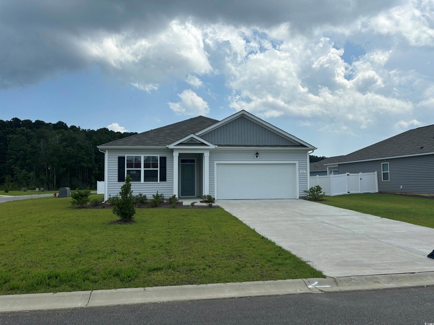 View of front of home with a garage and a front ya