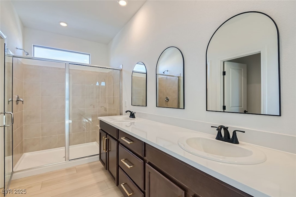 Bathroom with a stall shower, a sink, and double v