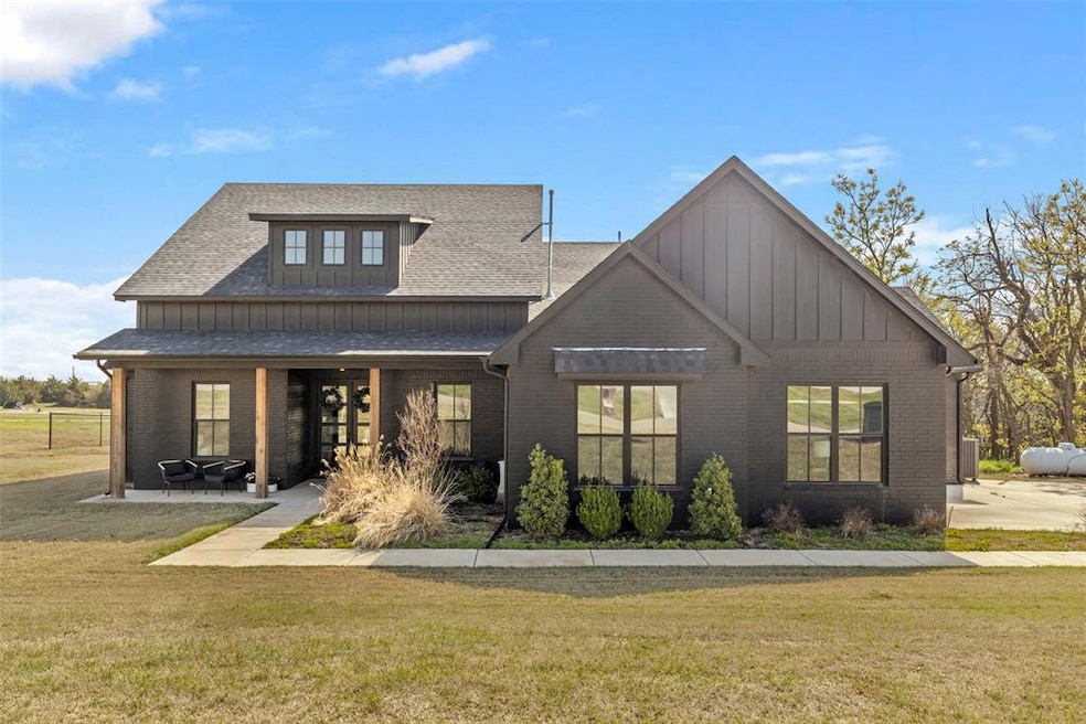 Back of house with a lawn, board and batten siding