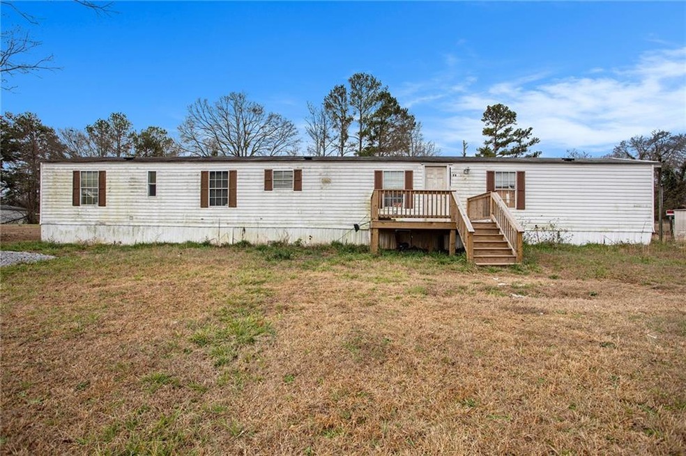 Rear view of property featuring a yard and a wooden deck