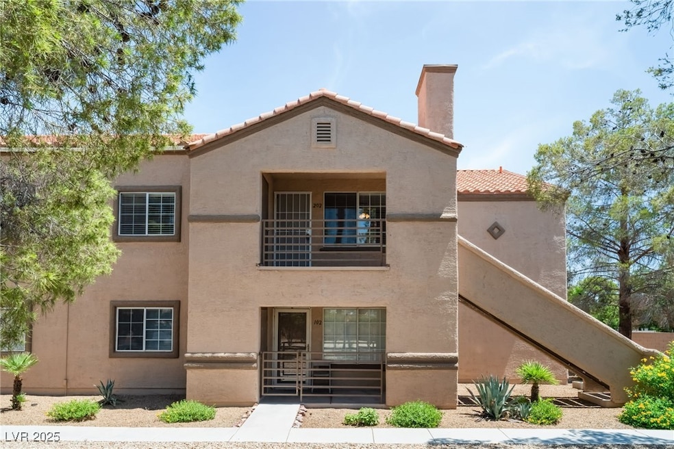 View of front of home featuring a tiled roof, stucco siding, and a chimney