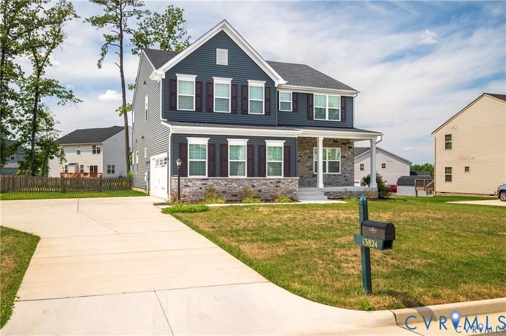 View of front facade featuring a porch, driveway, stone siding, and an attached garage