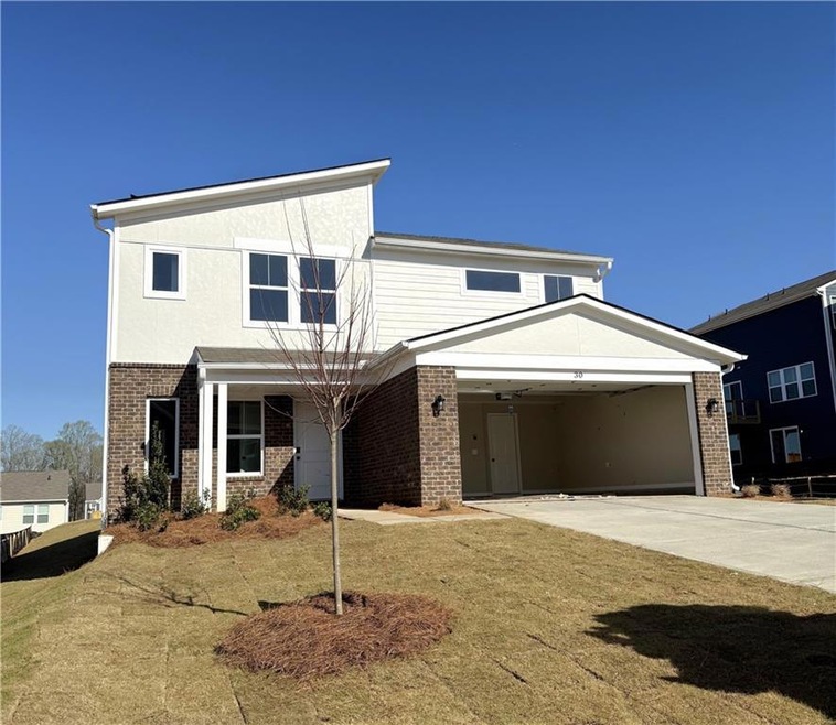 View of front of house with driveway, a garage, and brick siding