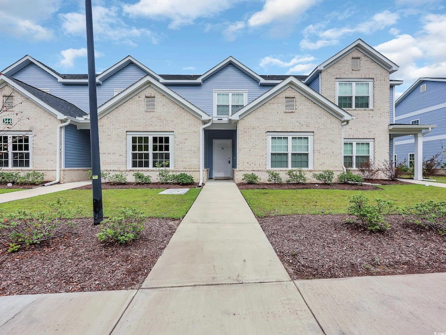 Traditional-style house with a front yard and brick siding