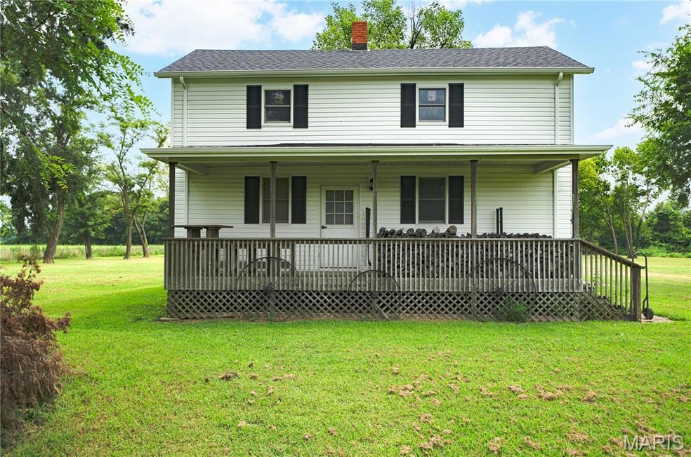Front view of home and front lawn, and a wooden deck