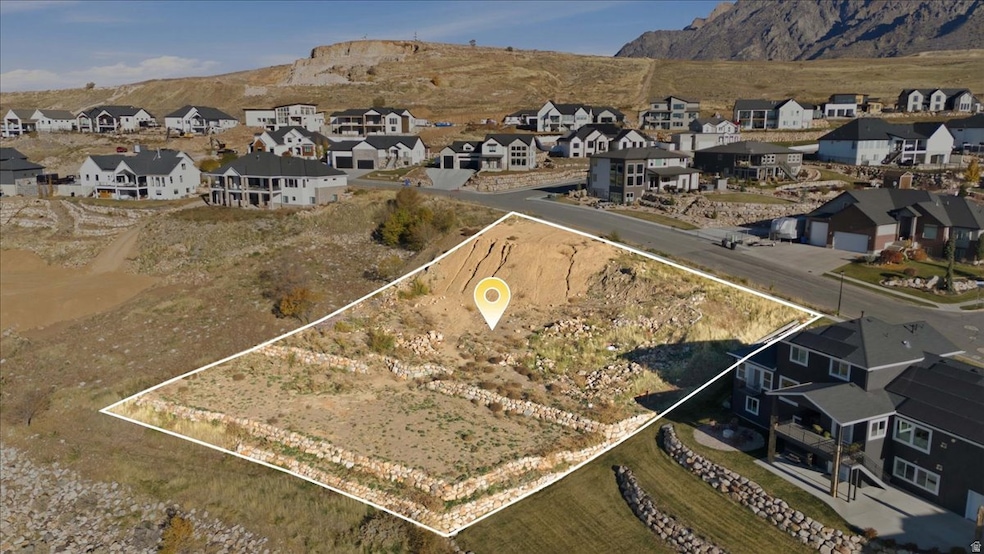 Aerial view of property's location with nearby suburban area and a mountainous background