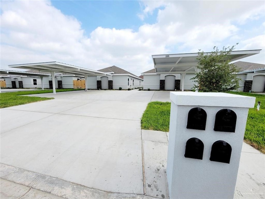 View of front of house featuring driveway, a carport, and stucco siding