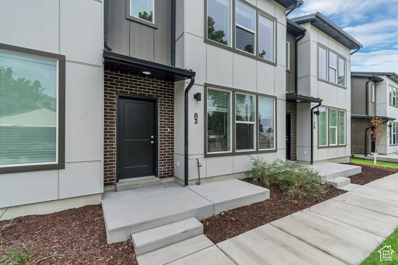 Doorway to property featuring brick siding and board and batten siding