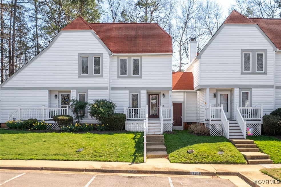 View of front facade with covered porch, a front yard, uncovered parking