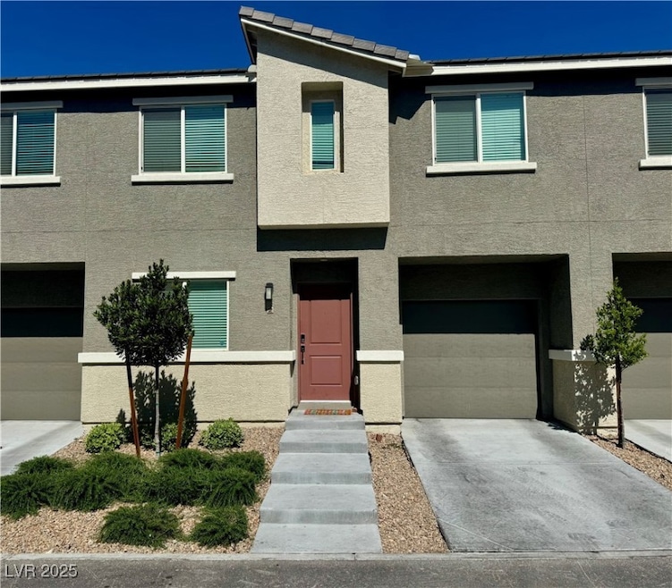 View of property with a garage, stucco siding, and