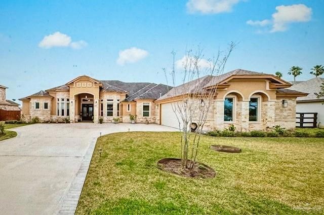 View of front of property featuring a garage and a front lawn