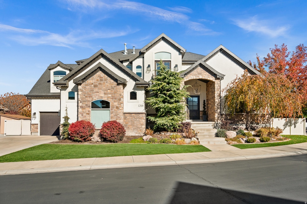 French provincial home with stone siding, stucco siding, a garage, and concrete driveway