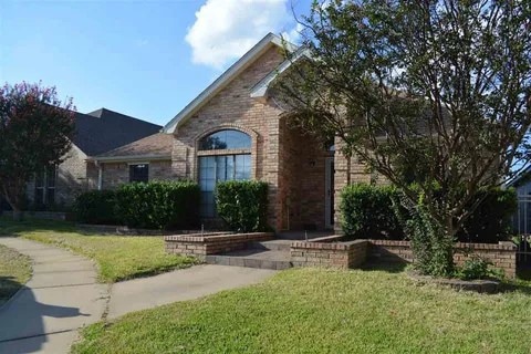 View of front of home featuring brick siding and a front yard