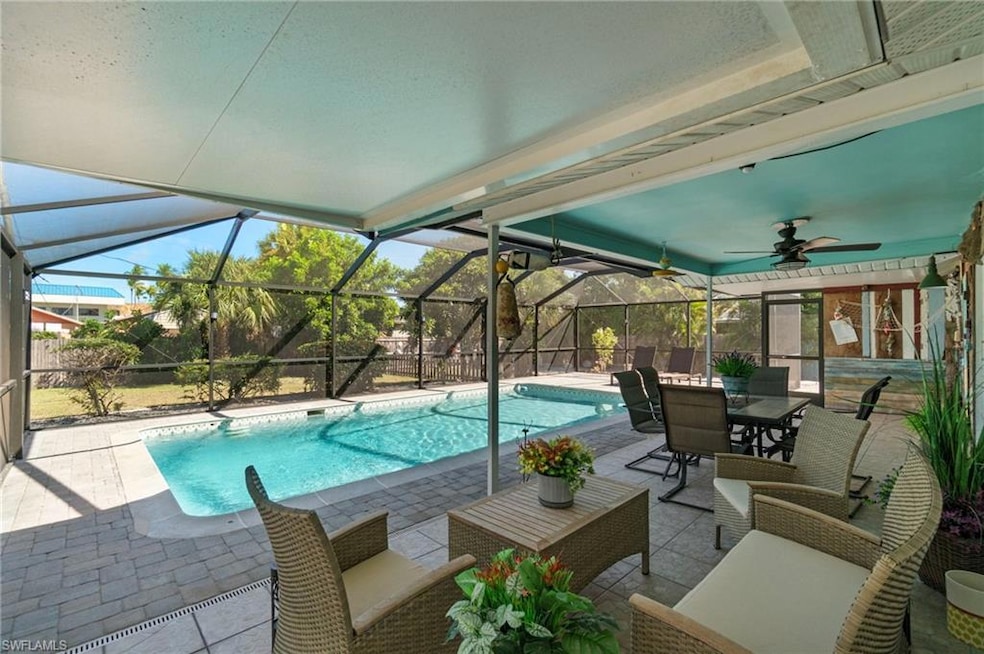 View of pool featuring a sunroom, a patio, glass enclosure, and a ceiling fan
