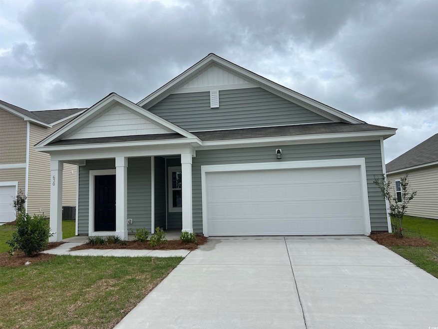 View of front facade with concrete driveway, a porch, an attached garage, and a front yard