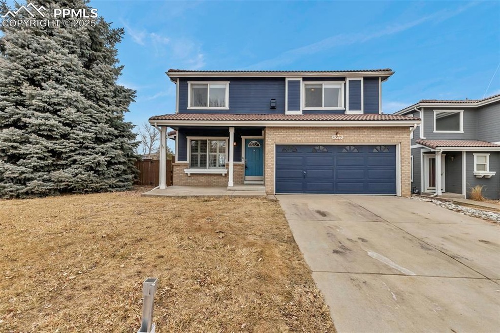 Traditional home with driveway, a tile roof, an at