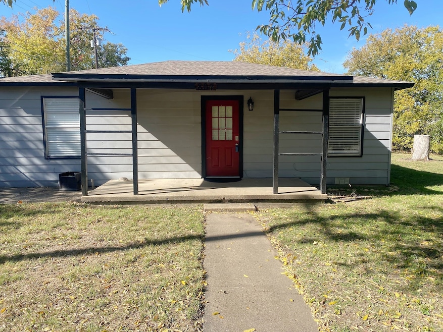 View of front of home featuring a porch, a front lawn, and a shingled roof