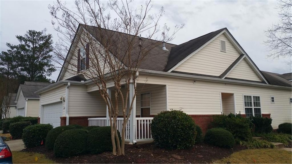 View of side of home featuring a porch and a garag