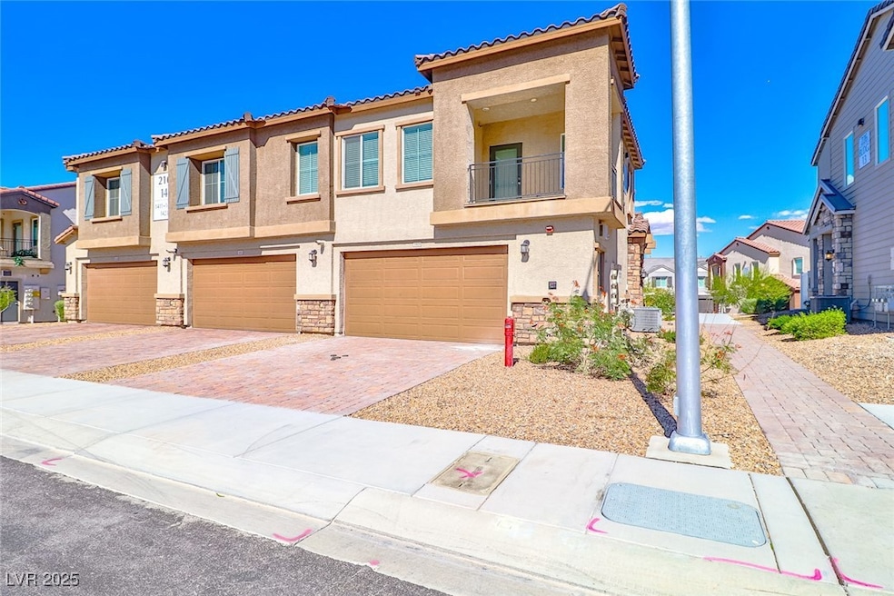Mediterranean / spanish house with a residential view, stucco siding, a balcony, stone siding, and decorative driveway