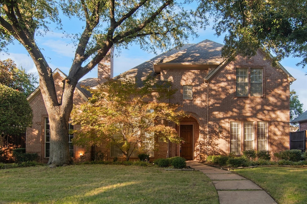 Tudor house featuring a front lawn, brick siding, and a chimney