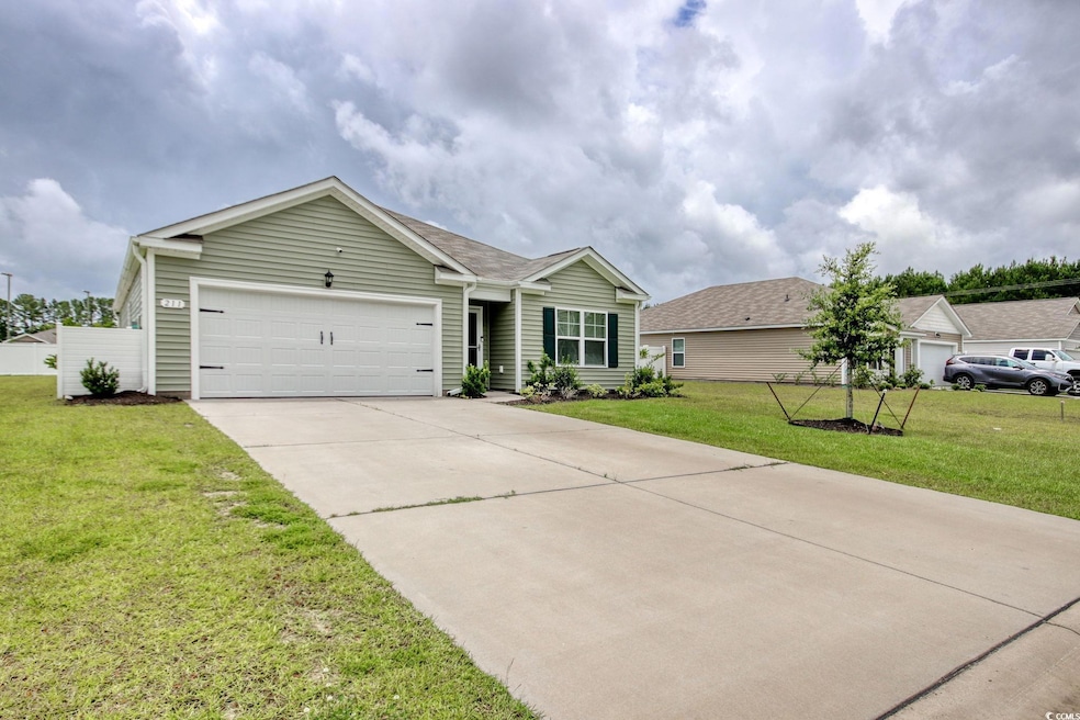 Ranch-style house featuring a garage, concrete driveway, and a front lawn