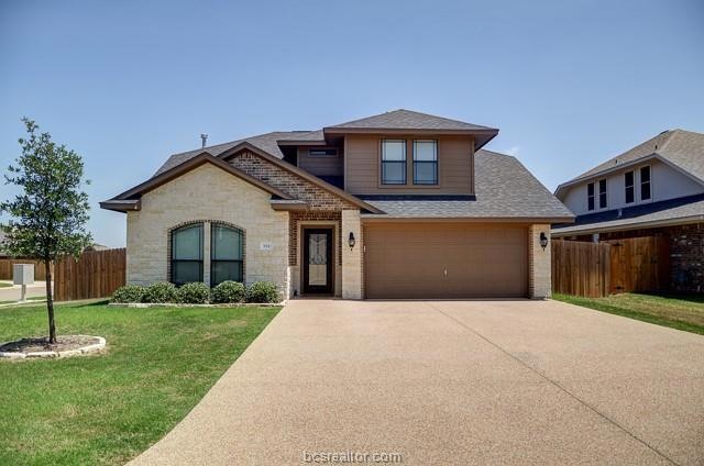 View of front facade with a front yard and a garage