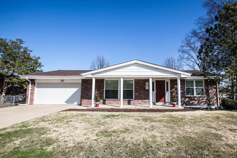 Front view of home with 2 car garage and brick front