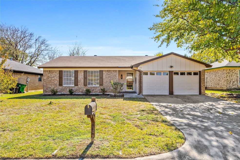 Single story home featuring a front yard, driveway, board and batten siding, and brick siding