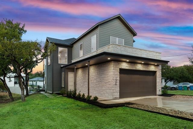 Property exterior at dusk with a lawn, stone sidi