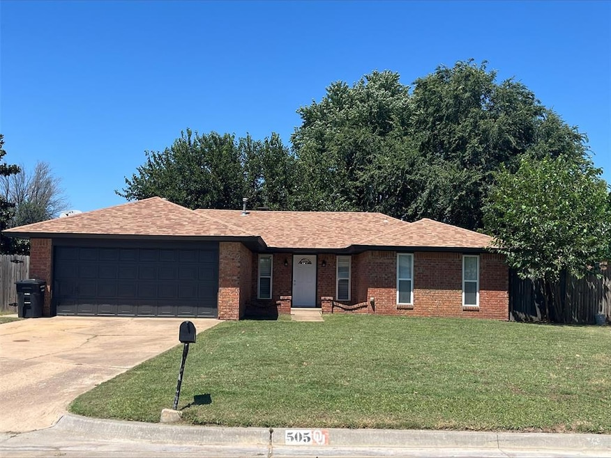 Ranch-style house with a garage and a front lawn