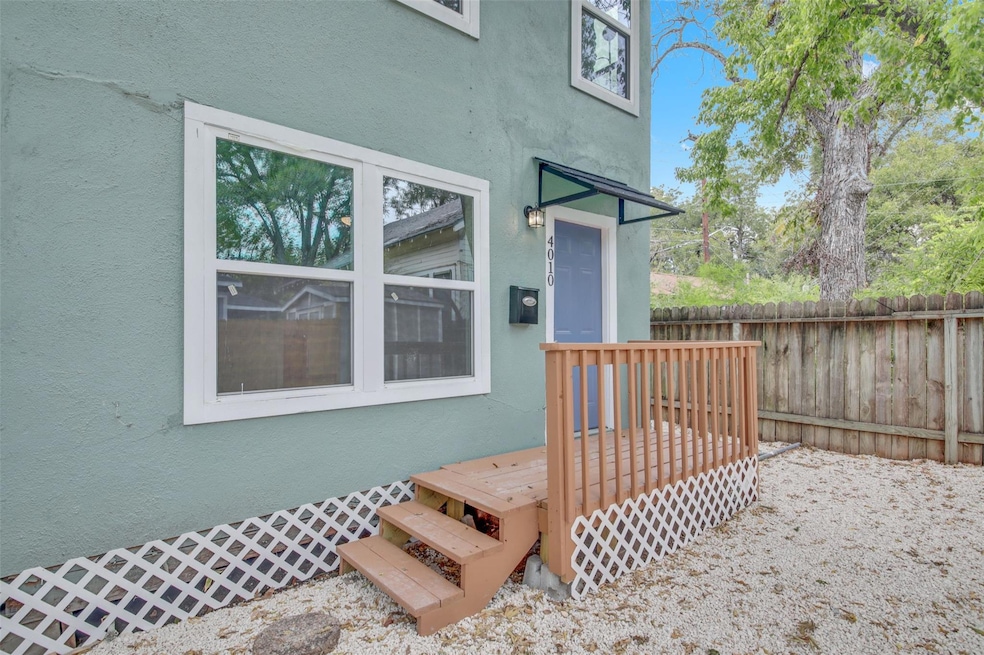 View of exterior entry with stucco siding and a deck