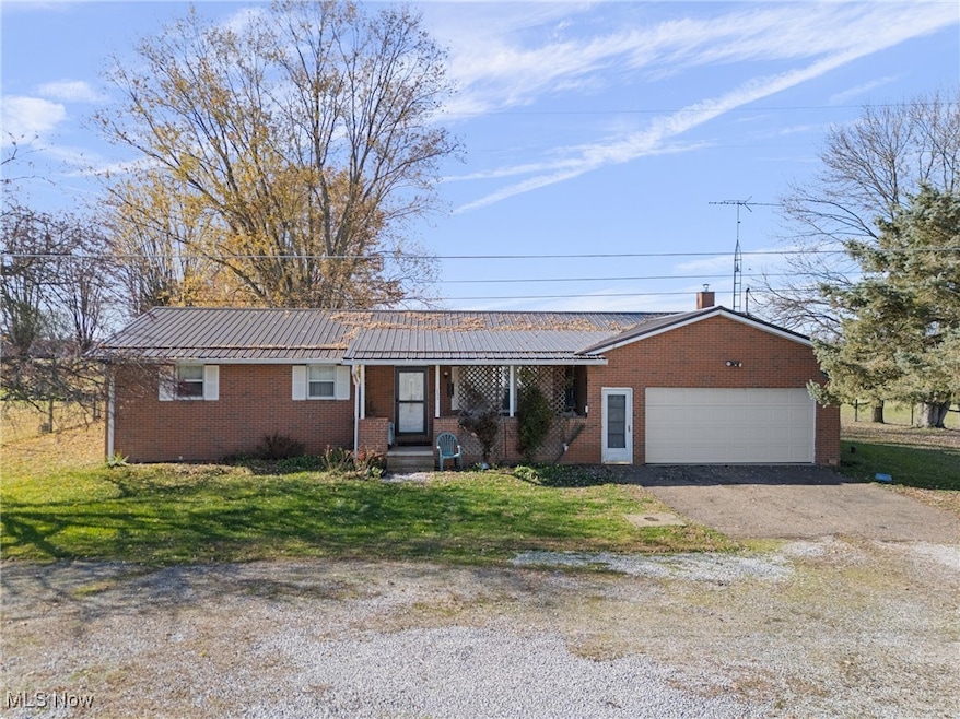 Single story home with brick siding, a front yard, asphalt driveway, and a porch