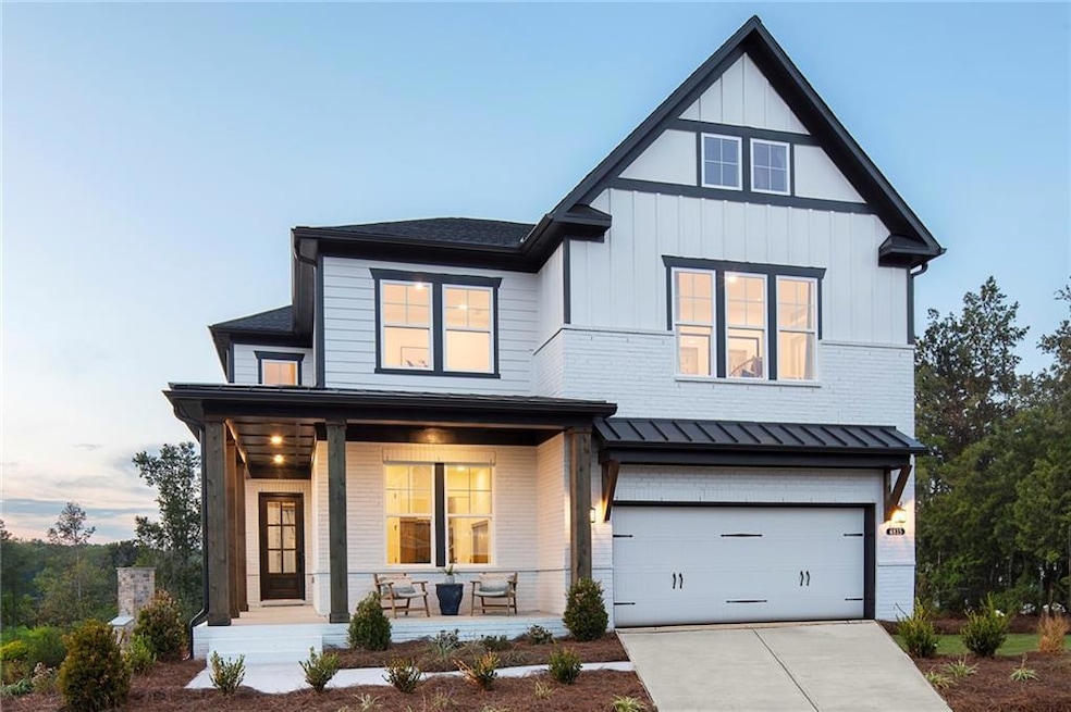 Modern farmhouse with brick siding, covered porch, 2 car garage and board and batten siding. Photo is representative of the Acworth Model Home. Designer features will vary.