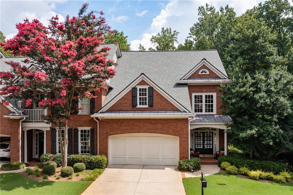 View of front of home with a balcony, a garage, an