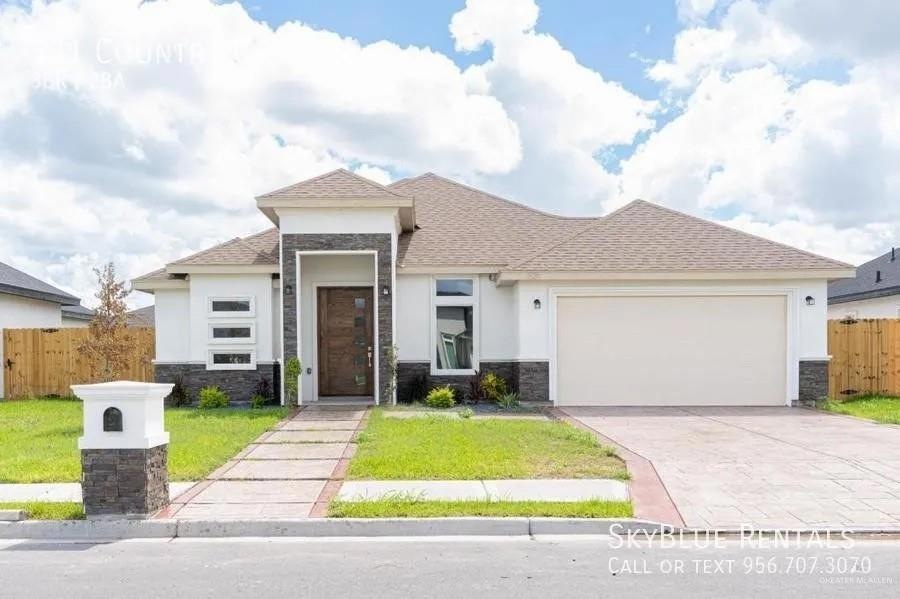 View of front of house with a garage and a front yard