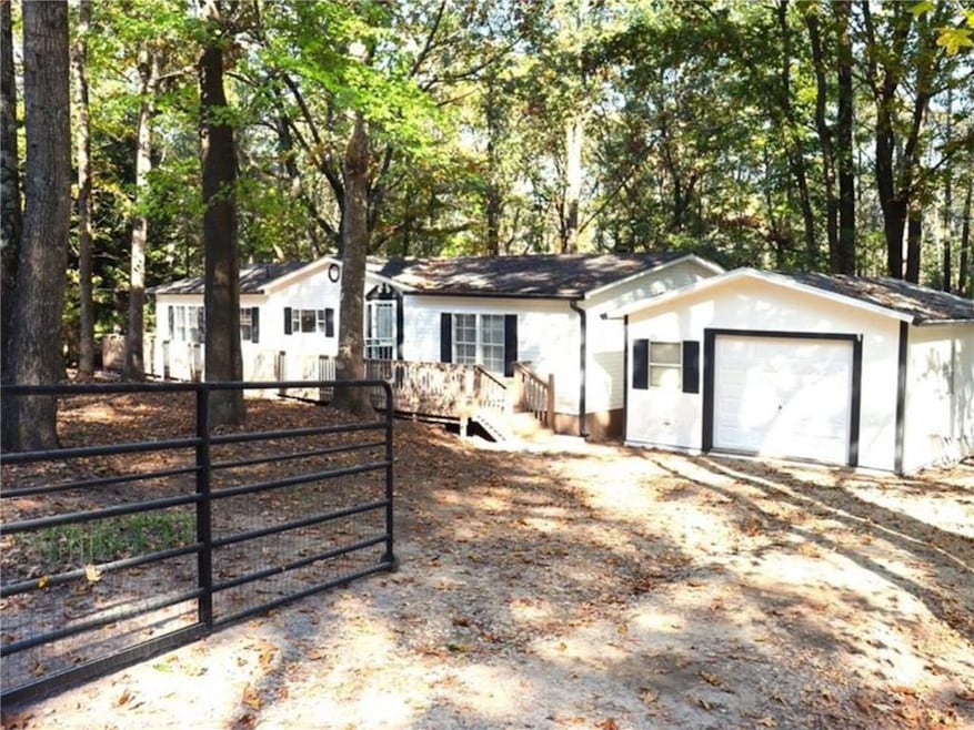 Single story home featuring fence, a garage, a gate, and driveway