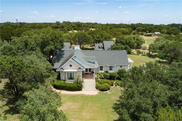 Front facade of owner designed home with guest cottage separate from main house. Home exterior is a combination of stone & hardi-plank shingle giving it a coastal feel. Portal-style windows add to this flavor. Owners have replaced many windows throug
