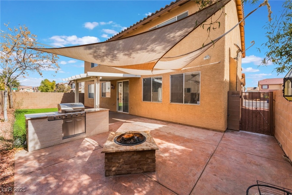View of patio with a fire pit, a gate, fence, and