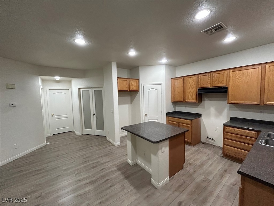 Kitchen featuring brown cabinets, dark countertops
