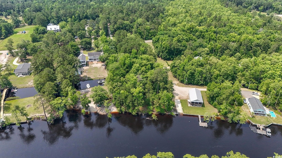 View of property location with a heavily wooded area and a large body of water