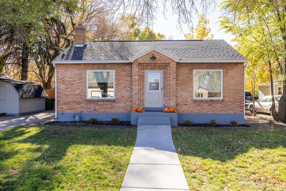Bungalow featuring a front yard, roof with shingles, and brick siding