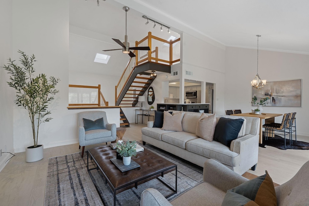 Living area with stairway, a chandelier, light wo