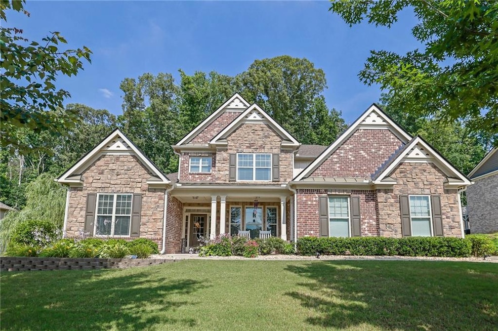 Craftsman-style house featuring a front lawn, a porch, and stone siding