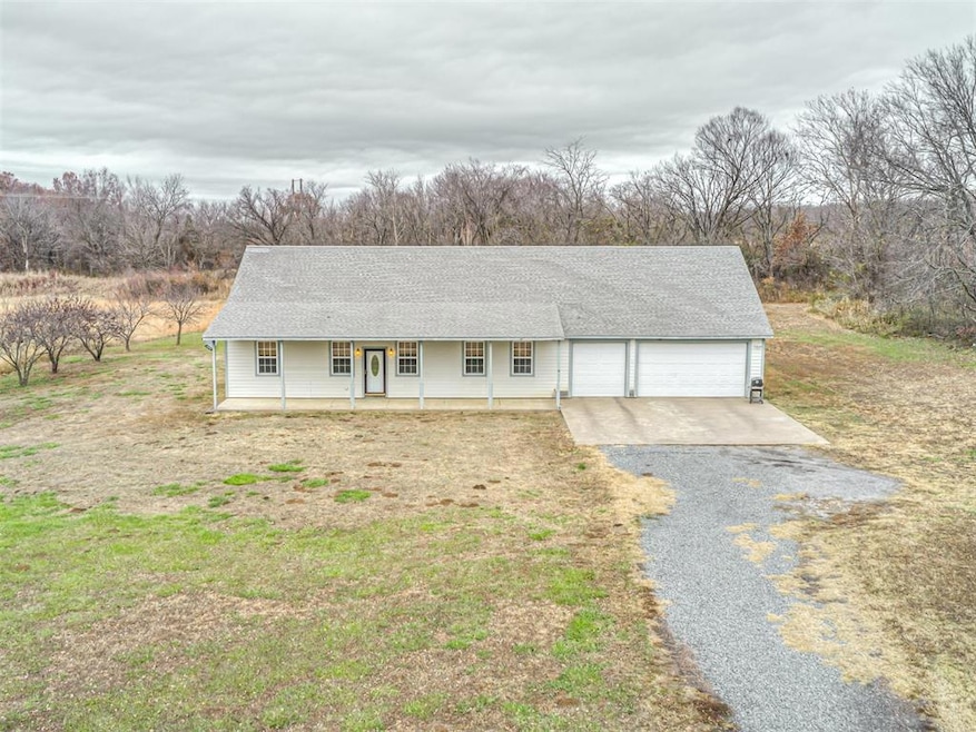 View of front of property featuring a porch, a garage, and a front lawn