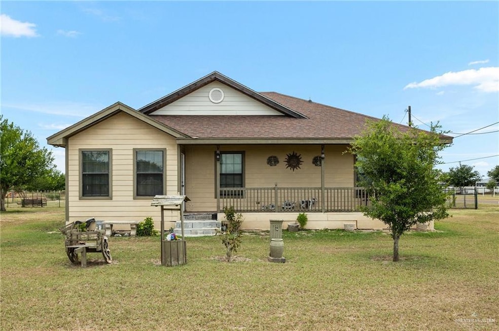 View of front of home with a porch, a shingled roof, and a front yard