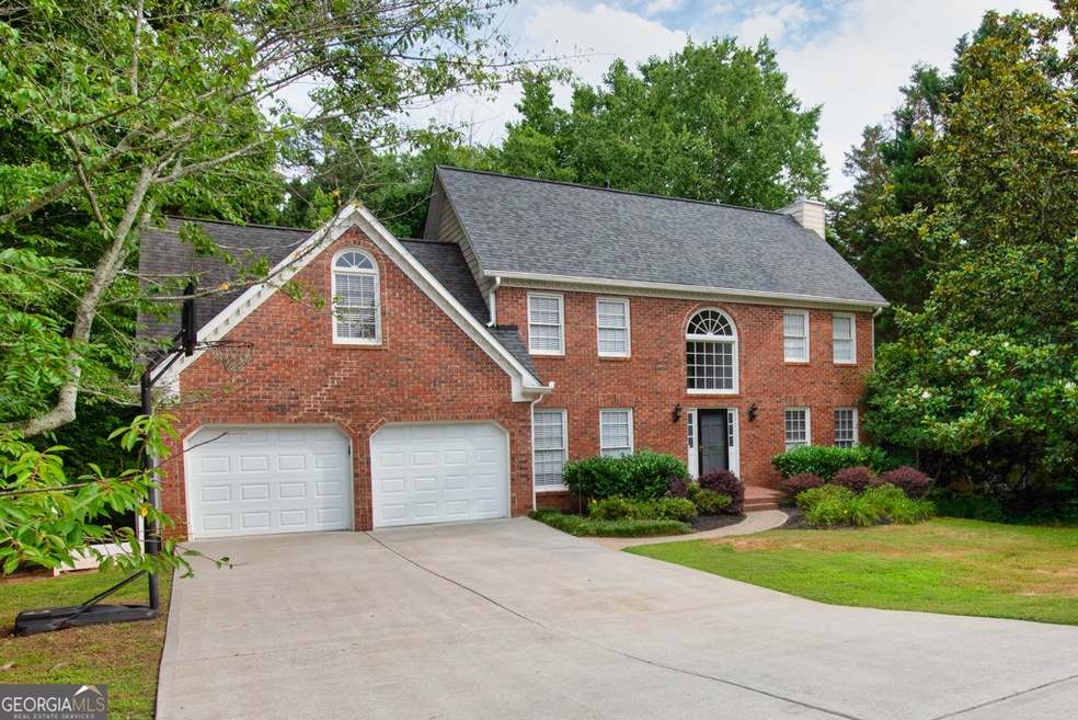 Colonial-style home featuring double garage doors,